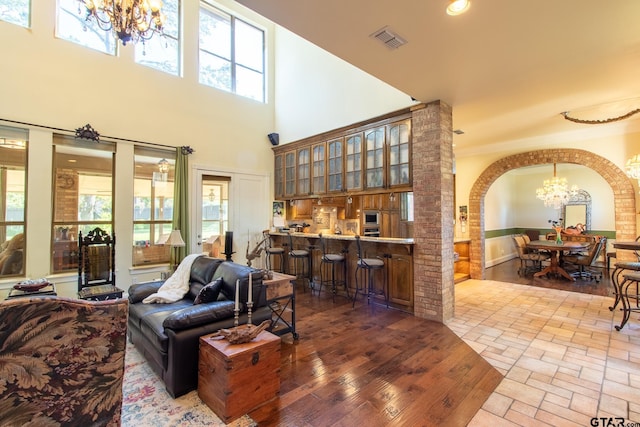 living room with hardwood / wood-style floors, a wealth of natural light, a high ceiling, and crown molding