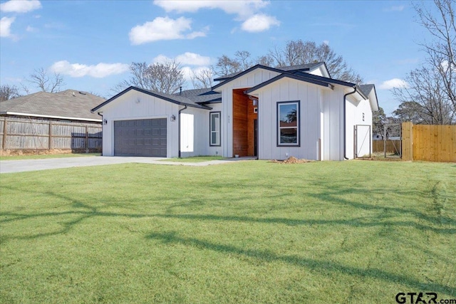 view of front facade featuring concrete driveway, an attached garage, fence, and a front lawn