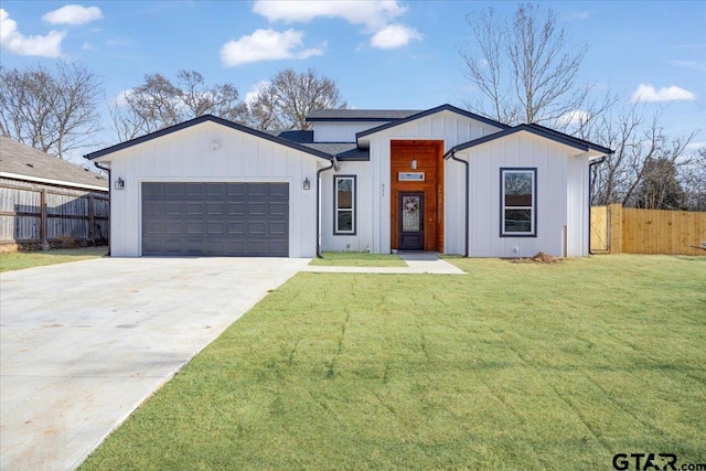 view of front of house with a garage, driveway, a front lawn, and fence