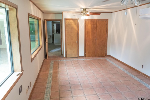 4010 Silverwood Dr, Tyler, TX 75701 - unfurnished bedroom featuring inlaid floor details, a wall mounted AC, multiple windows, crown molding, and light tile patterned floors