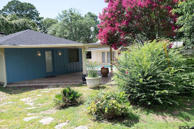 4010 Silverwood Dr, Tyler, TX 75701 - back of property with a shingled roof, a patio, an outdoor pool, board and batten siding, and a chimney