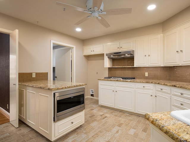 4010 Silverwood Dr, Tyler, TX 75701 - kitchen with stainless steel appliances, recessed lighting, white cabinetry, ceiling fan, and decorative backsplash