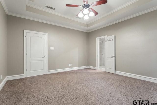 carpeted spare room with a raised ceiling, crown molding, and ceiling fan