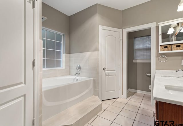 bathroom with tile patterned floors, vanity, toilet, and a bathing tub