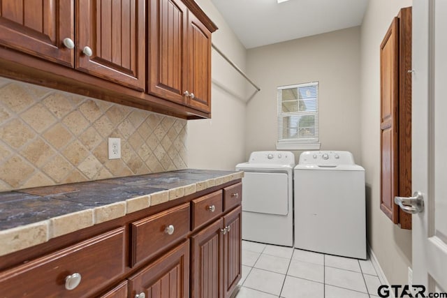 washroom featuring cabinets, washer and dryer, and light tile patterned flooring