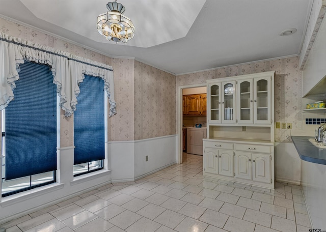 kitchen with white cabinets, an inviting chandelier, and ornamental molding