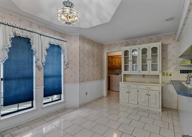 kitchen with white cabinets, an inviting chandelier, and ornamental molding