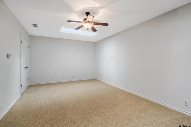 7117 Holly Square Ct, Tyler, TX 75703 - unfurnished room featuring a ceiling fan, light carpet, baseboards, and a skylight