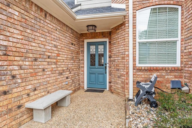 7117 Holly Square Ct, Tyler, TX 75703 - property entrance featuring a shingled roof and brick siding