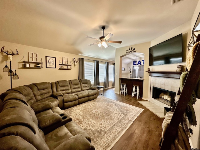 living room with ceiling fan, a fireplace, and dark hardwood / wood-style floors