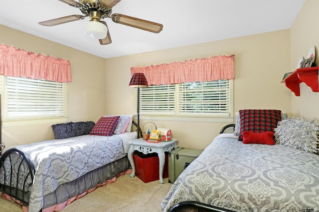 carpeted bedroom featuring multiple windows and ceiling fan