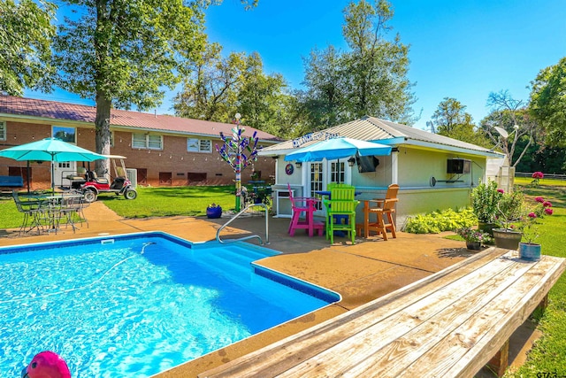 view of pool with a lawn and a patio