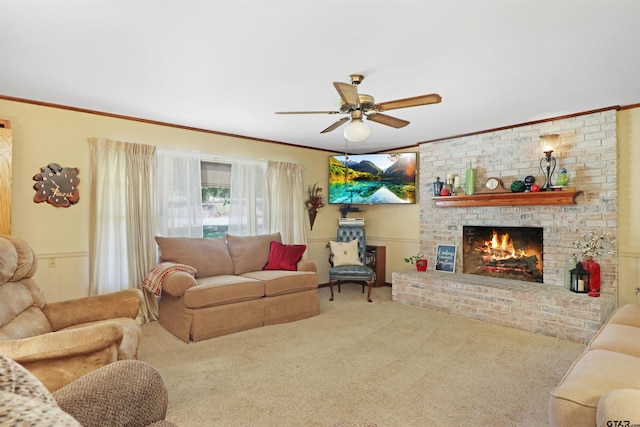 living room with a brick fireplace, ceiling fan, carpet flooring, and ornamental molding