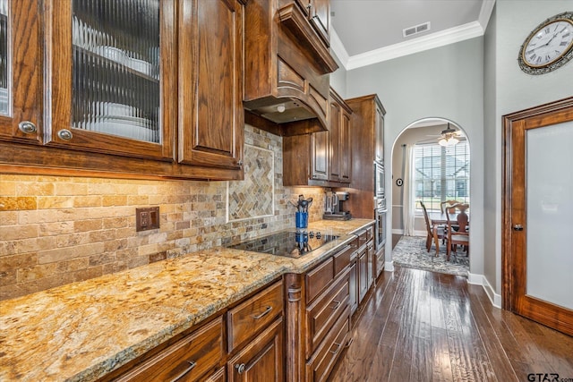 301 Zambezi Ln, Bullard, TX 75757 - kitchen with baseboards, arched walkways, black electric stovetop, light stone counters, and glass insert cabinets