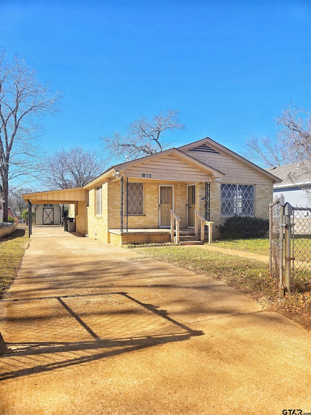 ranch-style home featuring covered porch and a carport