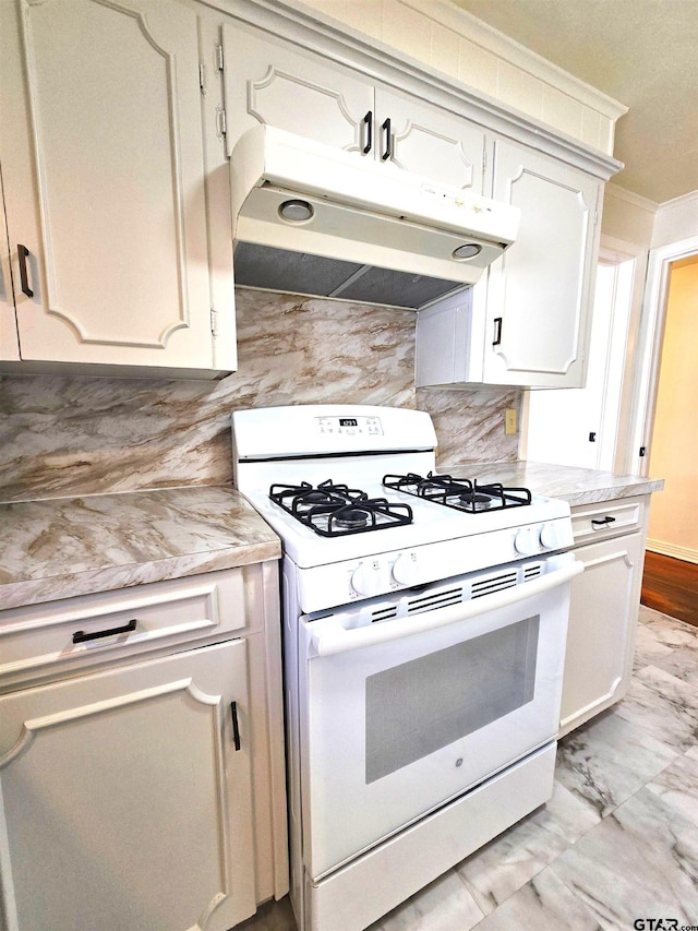 kitchen featuring white cabinets, white gas stove, and tasteful backsplash