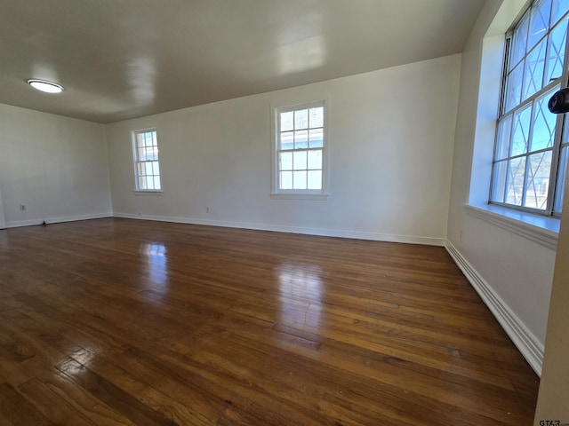 unfurnished room with dark hardwood / wood-style floors and a healthy amount of sunlight