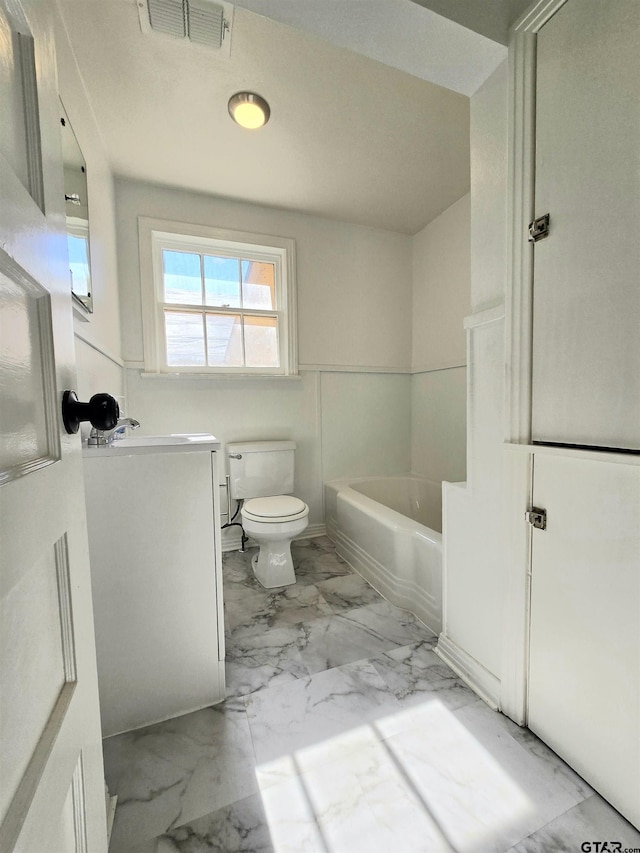 bathroom featuring a tub, toilet, and vanity