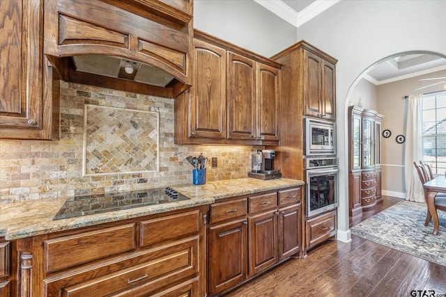 301 Zambezi Ln, Bullard, TX 75757 - kitchen featuring appliances with stainless steel finishes, arched walkways, backsplash, light stone counters, and crown molding