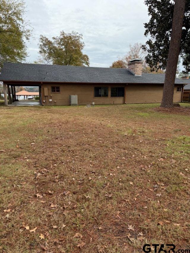 exterior space featuring a carport and a lawn