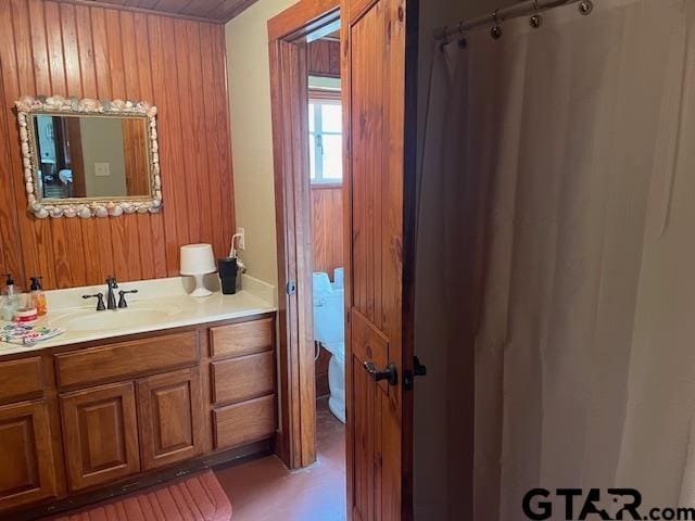 bathroom featuring vanity and wood walls