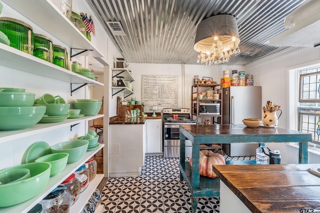 kitchen featuring butcher block countertops, a chandelier, and stainless steel appliances