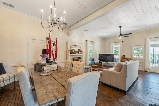 dining space featuring ceiling fan with notable chandelier, dark hardwood / wood-style flooring, and beamed ceiling