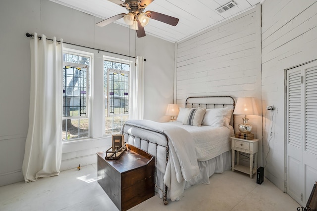 bedroom with ceiling fan, multiple windows, and a closet