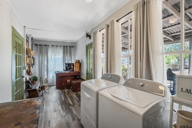 laundry area with hardwood / wood-style flooring, a healthy amount of sunlight, and washer and clothes dryer