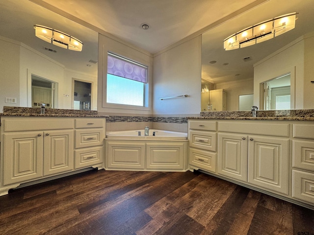 bathroom featuring crown molding, vanity, a garden tub, and wood finished floors