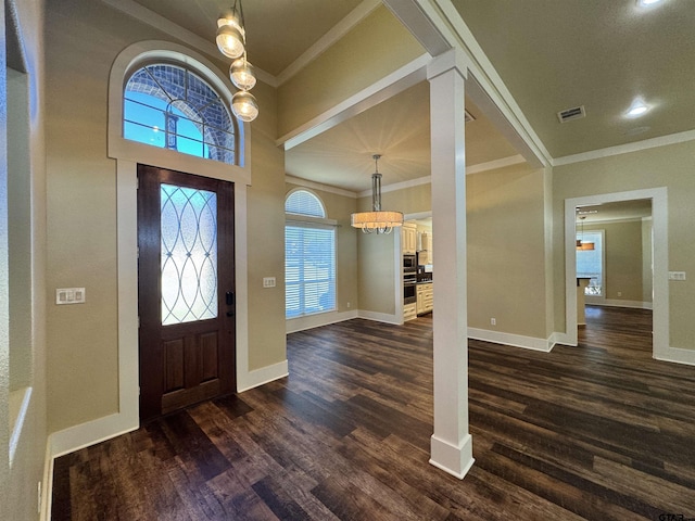 entryway featuring a chandelier, ornamental molding, baseboards, visible vents, and dark wood-style floors