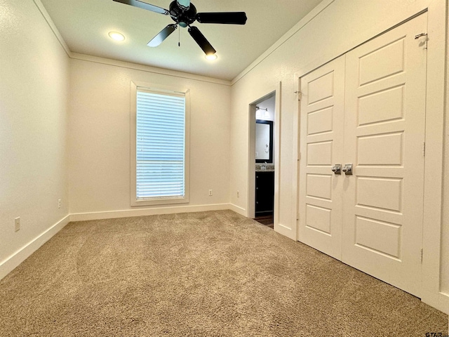 unfurnished bedroom featuring baseboards, ornamental molding, ensuite bathroom, and carpet