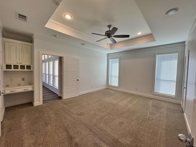 unfurnished bedroom with a raised ceiling, carpet, recessed lighting, baseboards, and visible vents