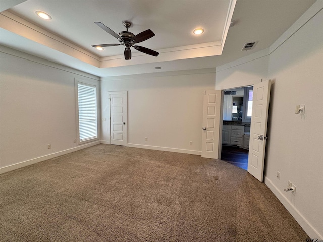 unfurnished bedroom with visible vents, recessed lighting, a raised ceiling, and dark colored carpet