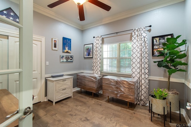 interior space with ornamental molding, wood-type flooring, and ceiling fan