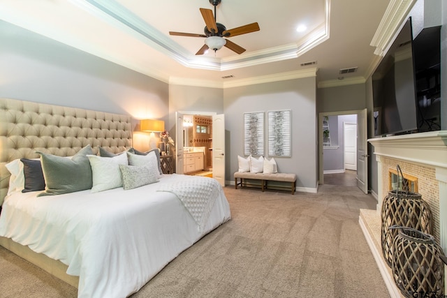 bedroom with carpet, crown molding, connected bathroom, a tray ceiling, and ceiling fan