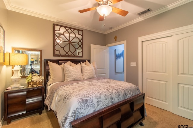 carpeted bedroom with ceiling fan, a closet, and crown molding