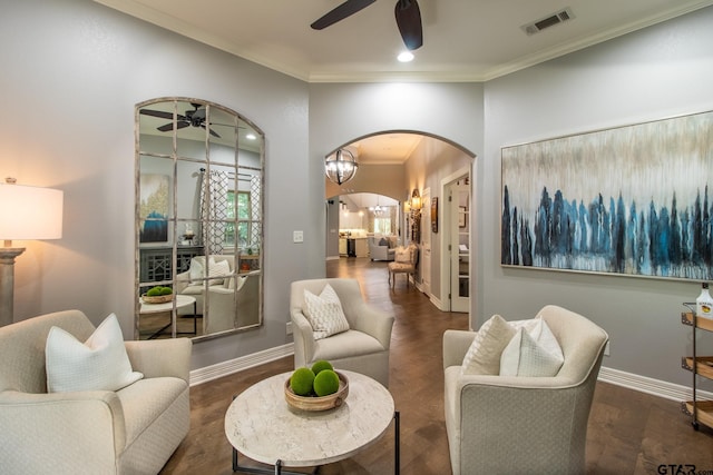 living room with dark hardwood / wood-style flooring, ceiling fan, and crown molding