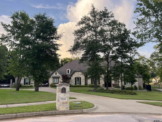 7532 Northlake Dr, Tyler, TX 75703 - french country style house with stone siding, curved driveway, and a front yard