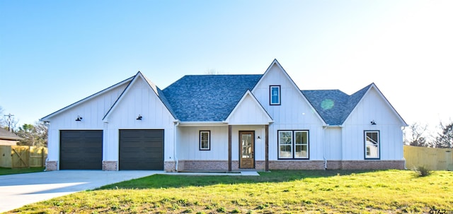 modern farmhouse style home featuring a front lawn and a garage