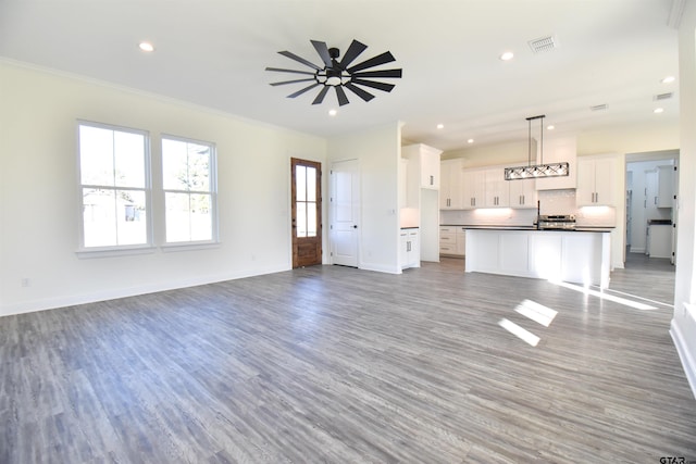 unfurnished living room featuring ceiling fan, light hardwood / wood-style floors, and ornamental molding