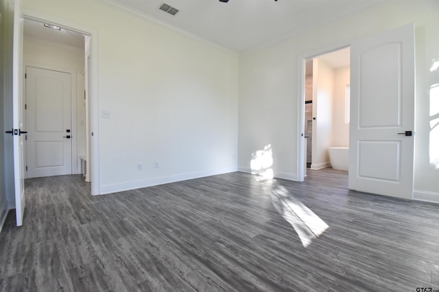 empty room featuring crown molding and dark wood-type flooring