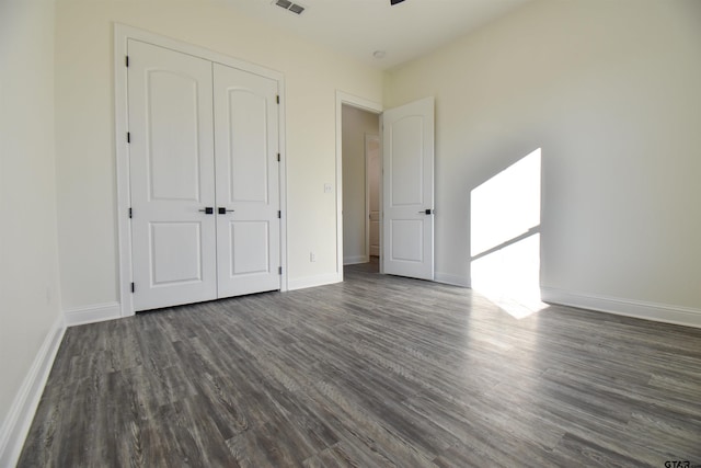 unfurnished bedroom featuring dark hardwood / wood-style floors and a closet