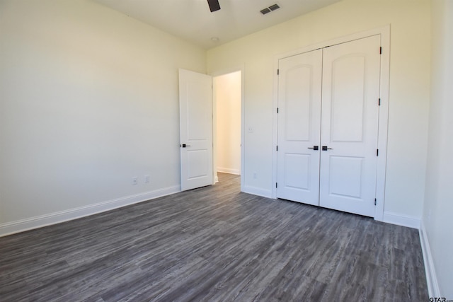 unfurnished bedroom with ceiling fan, a closet, and dark hardwood / wood-style floors