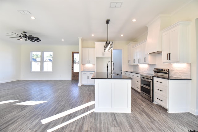 kitchen with double oven range, white cabinets, sink, hanging light fixtures, and ceiling fan