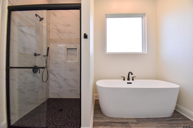 bathroom with separate shower and tub, a wealth of natural light, and hardwood / wood-style floors