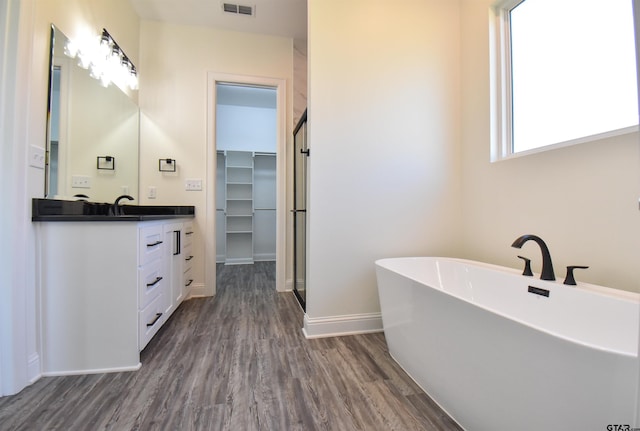 bathroom featuring hardwood / wood-style floors, vanity, and separate shower and tub