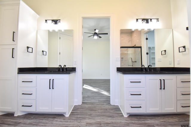 bathroom with ceiling fan, vanity, wood-type flooring, and a shower with shower door