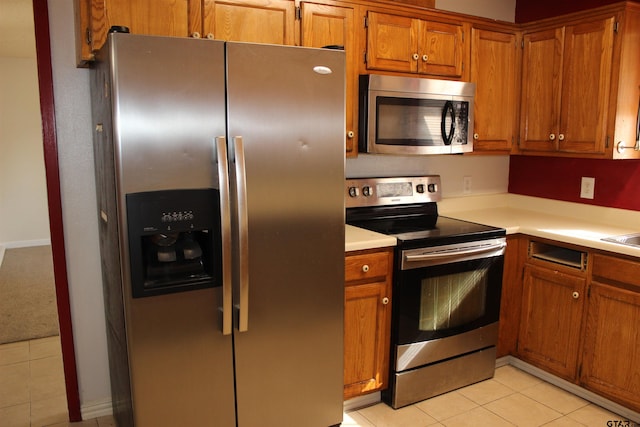 kitchen with appliances with stainless steel finishes and light tile patterned floors