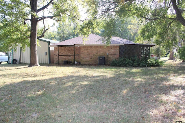 view of side of property featuring central AC unit and a lawn